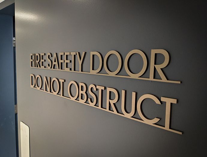 Statutory fire door safety sign for wayfinding and compliance